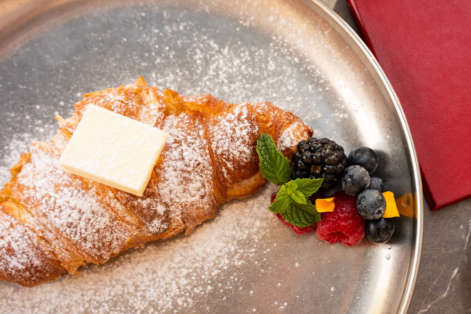 Croissant con mantequilla y frutos rojos en Bar Plaza